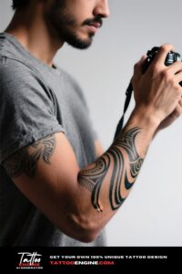 Close-up of a man's arm with a Hawaiian tribal tattoo holding a camera
