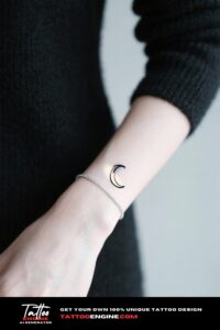 Close-up of a woman's wrist with a crescent moon tattoo and a silver bracelet