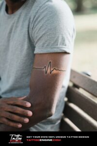 Extreme close-up of a minimalist heartbeat tattoo on a man's inner forearm with a maroon shirt.