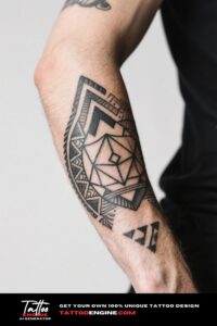 Close-up of a man's forearm with a complex geometric tattoo in a dark blue short-sleeve shirt.
