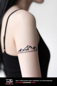 Cinematic shot of a woman's arm with a mountain range tattoo, wearing an olive green top.
