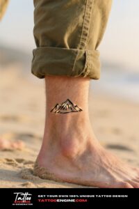 Extreme close-up of a minimalist mountain tattoo on a man's ankle at the beach.