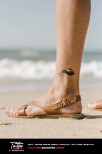 Close-up of a woman's ankle with a wave tattoo and leather sandals