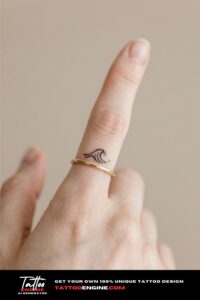 Close-up of a woman's finger with a wave tattoo