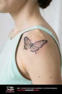 Airy fine line butterfly tattoo on beige shoulder, mint green racerback vest strap aside.