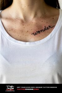 Healed script tattoo "wander" on a woman&rsquo;s collarbone, white t-shirt neckline below.