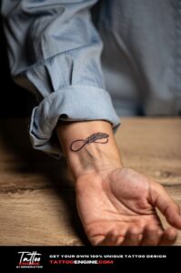 Close-up of a healed infinity feather tattoo on a woman’s inner wrist in fine black lines.