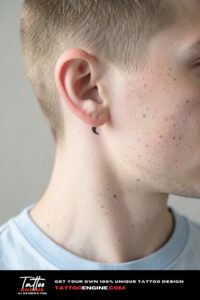 Minimalist crescent moon tattoo behind the ear on fair freckled skin, soft indoor daylight.