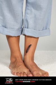 Black feather tattoo on woman's outer right ankle, minimalist fine line style.