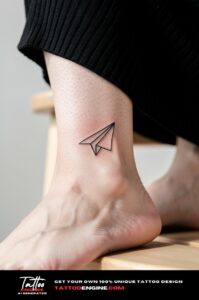 Simple paper airplane tattoo on a woman&rsquo;s outer ankle, fine lines and precise detail.