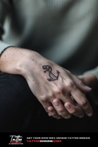 Small anchor tattoo on outer wrist, light freckled skin, sage shirt, soft daylight.
