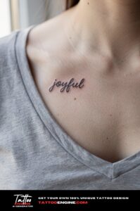 A woman&rsquo;s collarbone with a slim healed script tattoo "joyful", grey t-shirt pulled wide.