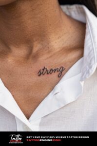 A woman&rsquo;s collarbone with a healed script tattoo "strong", open white shirt collar below.