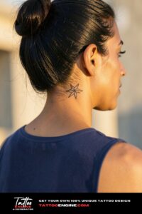Small fine-line star tattooed behind the jaw on a woman's neck.